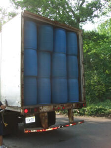 Blue barrel delivery container with filled barrels