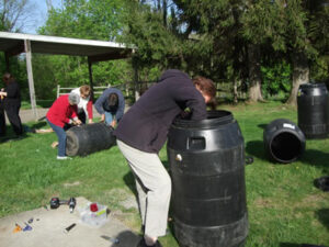 group of people preparing rain barrels